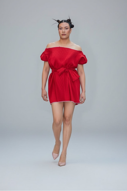 This photo shows a red pleated satin fabric mini dress with a size adjustable waist belt that ties to accommodate many sizes