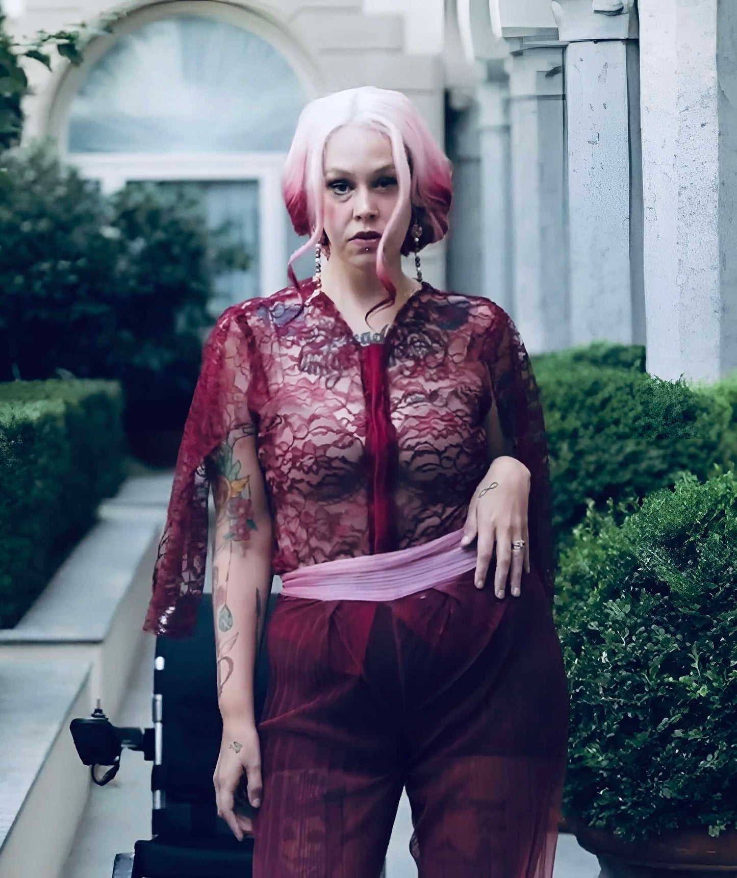 This photo shows a model wearing a lace top with cape sleeves.