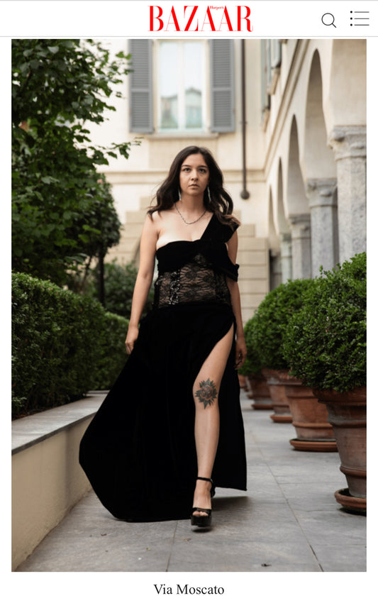 This is a photo published in Harper's Bazaar that shows a size adjustable floor length evening gown that is black lace and black velvet. The gown will stretch multiple sizes. 