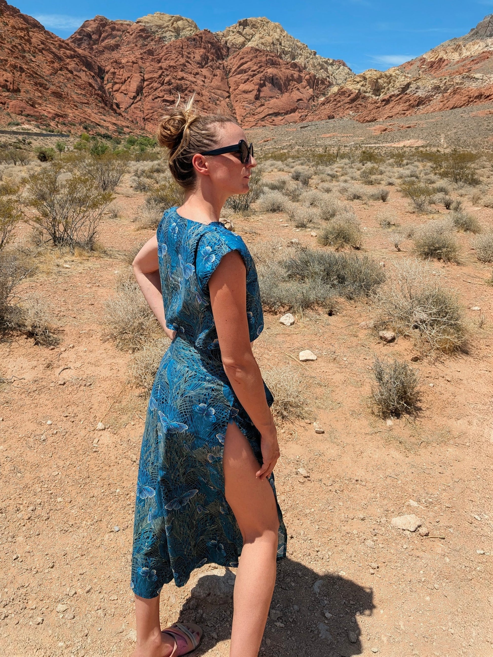 This photo shows a size adjustable two piece with a tie waistbelt as the waistband. The pattern on the fabric is a blue, moth themed cotton fabric. The top is a crop top with gold buttons.