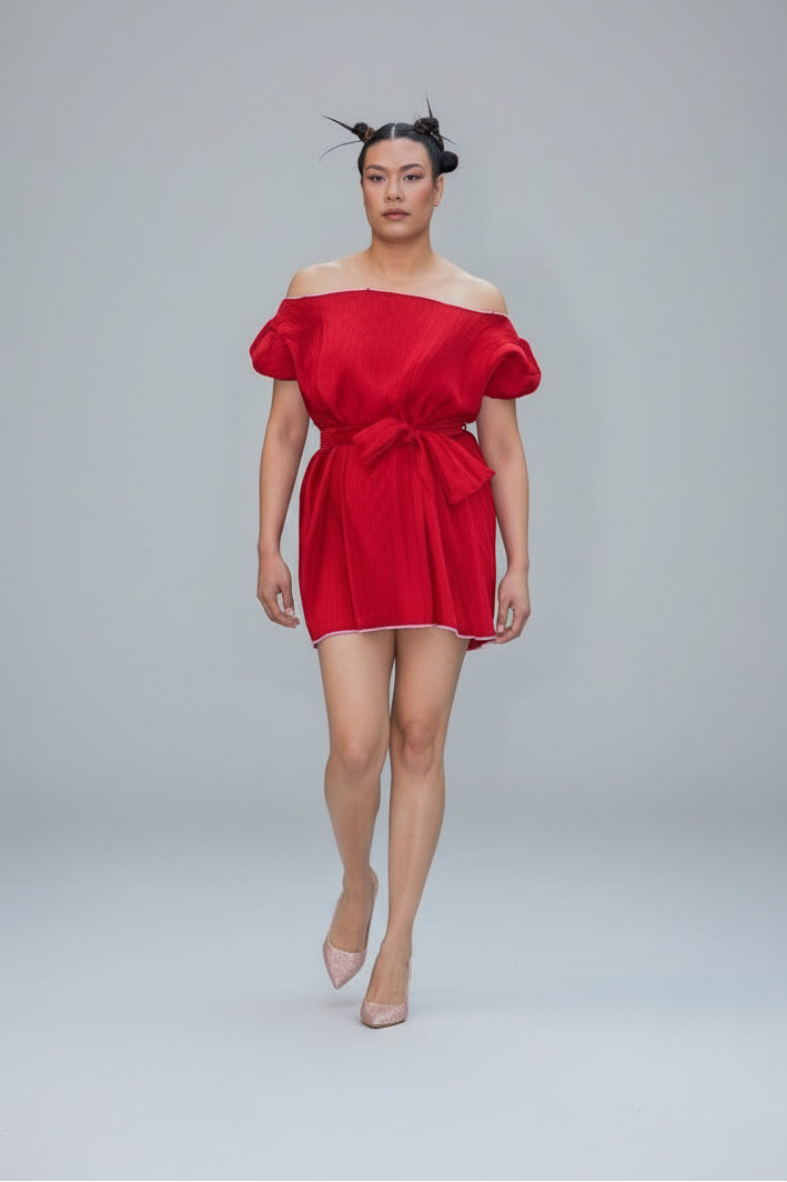 This photo shows a red pleated satin fabric mini dress with a size adjustable waist belt that ties to accommodate many sizes 