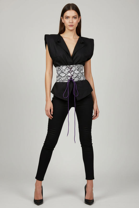 This photo shows a slim model wearing a black linen shirt with a black and white faux snake skin corset over the top 