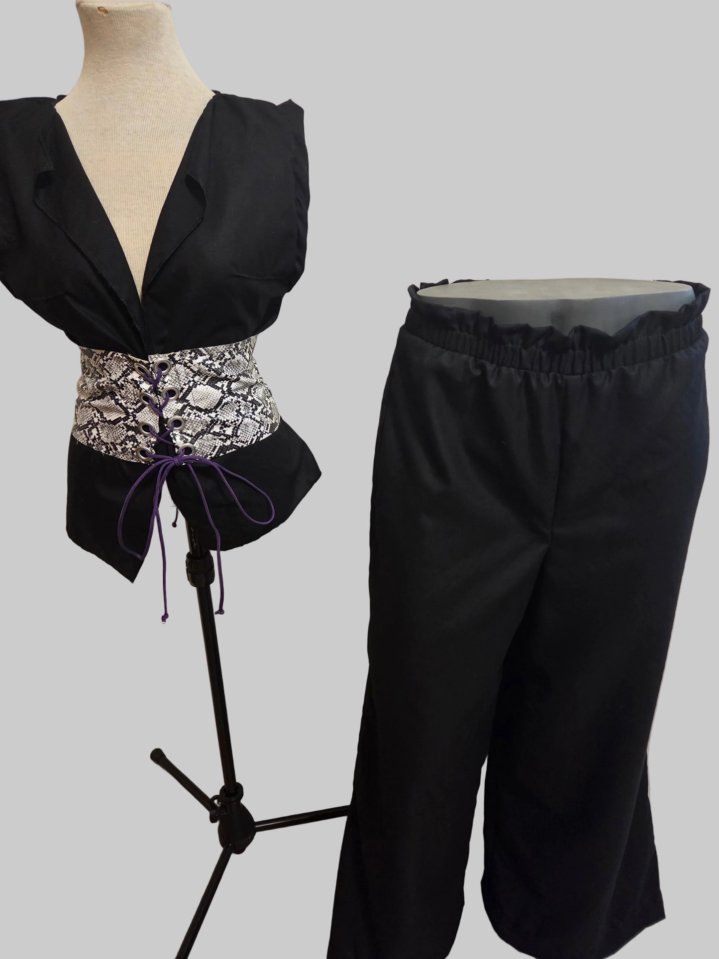 This photo shows a black linen top with a faux snake skin corset top that matches a size adjustable pair of black linen palazzo pants