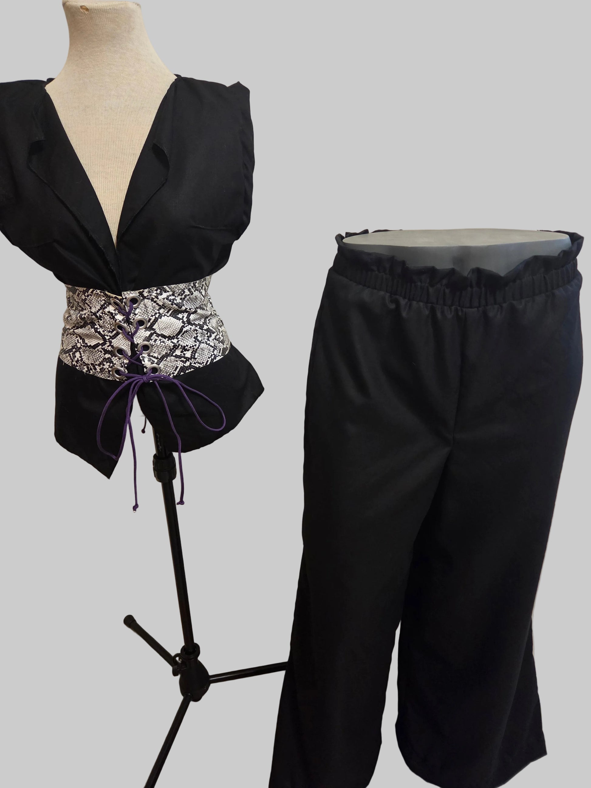 This photo shows a black linen top with a faux snake skin corset top that matches a size adjustable pair of black linen palazzo pants