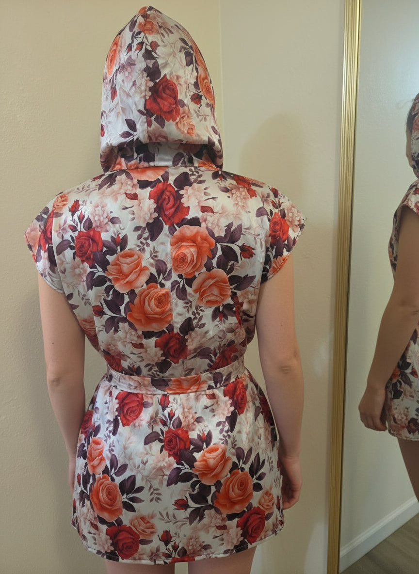 This photo shows a model wearing the red satin hooded size adjustable shirt with the waistbelt tied and the hood worn up. 