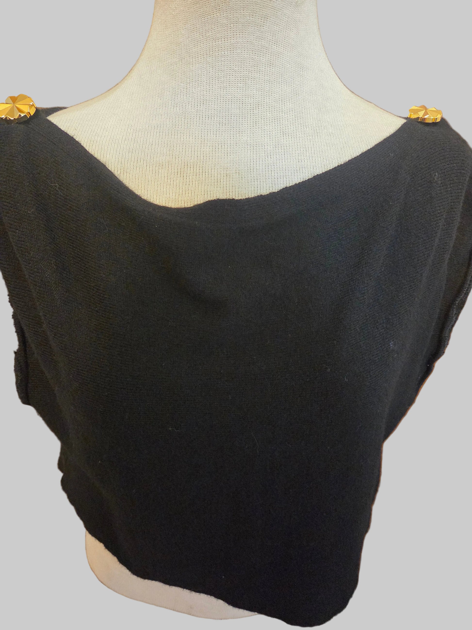 Tis photo shows a black, knit size-adjustable top with two button accents on the shoulders. 