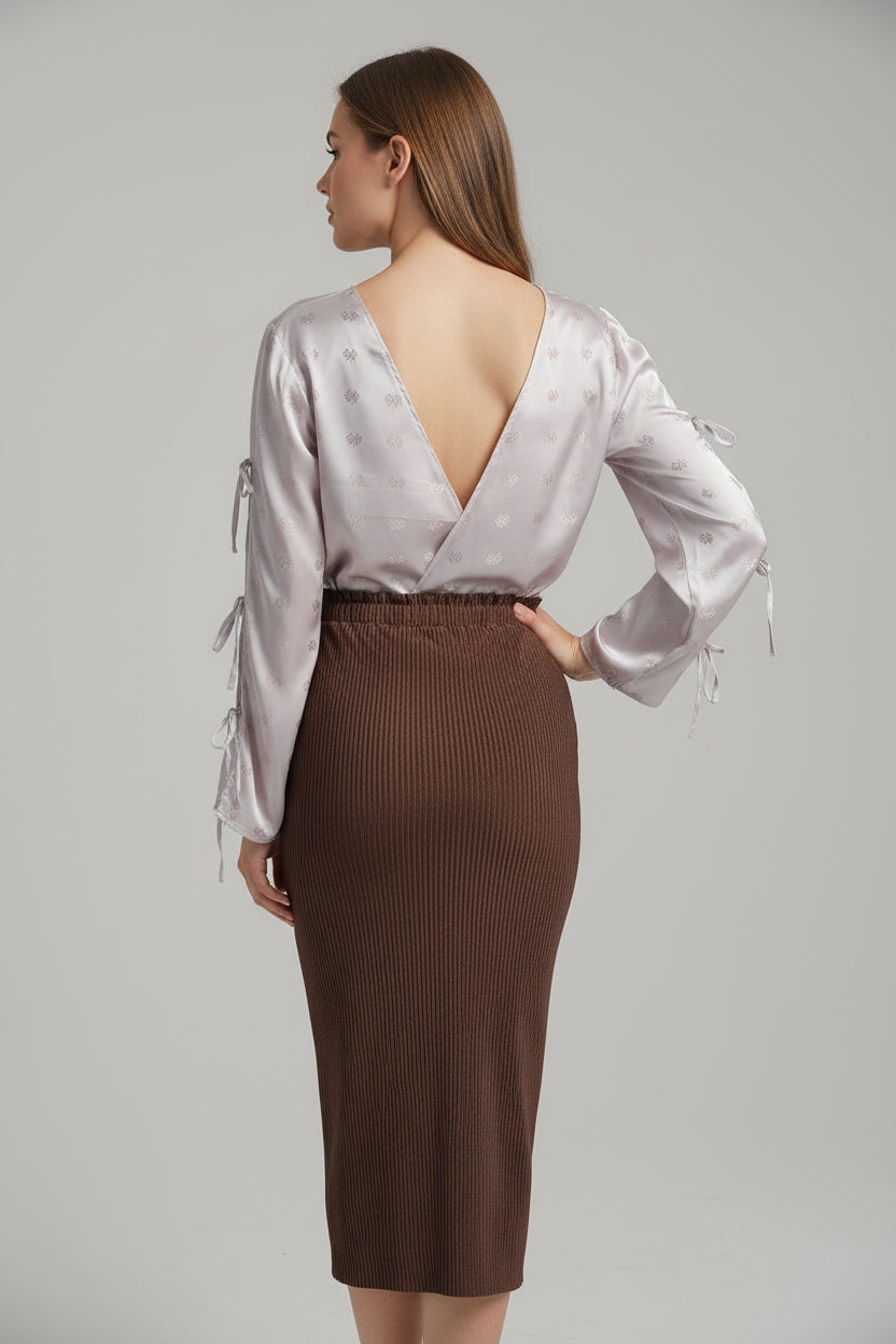 This photo shows a model wearing a size adjustable pencil skirt worn with a size adjustable shirt paired with the open back pink tie top. 