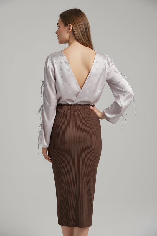 This photo shows a model wearing a size adjustable pencil skirt worn with a size adjustable shirt paired with the open back pink tie top. 