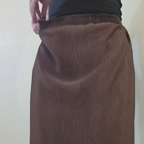 This video shows a model adjusting the waistbelt in the satin brown pleated pencil skirt