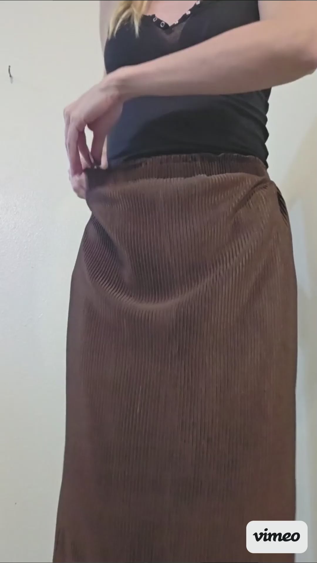 This video shows a model adjusting the waistbelt in the satin brown pleated pencil skirt