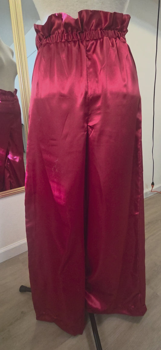 This video shows red satin pants with a size adjustable waistband that extends from an XS to an XL in size. 