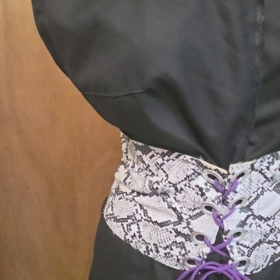 This video shows a black linen shirt that is size adjustable by way of a faux snake skin corset on top. 