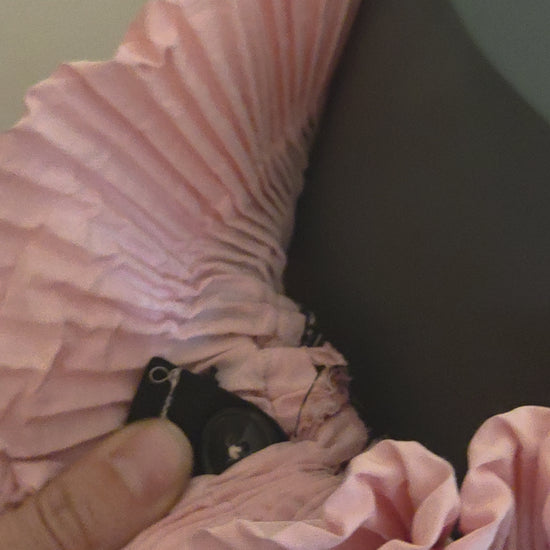 Tis vide shows the size adjustable waistband of our pink pleated skirt