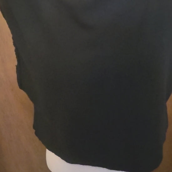 This photo shows a size adjustable black top made of soft knit, black fabric that is both stretchy and has the capability of tying at the back to accomplish different sizes. 