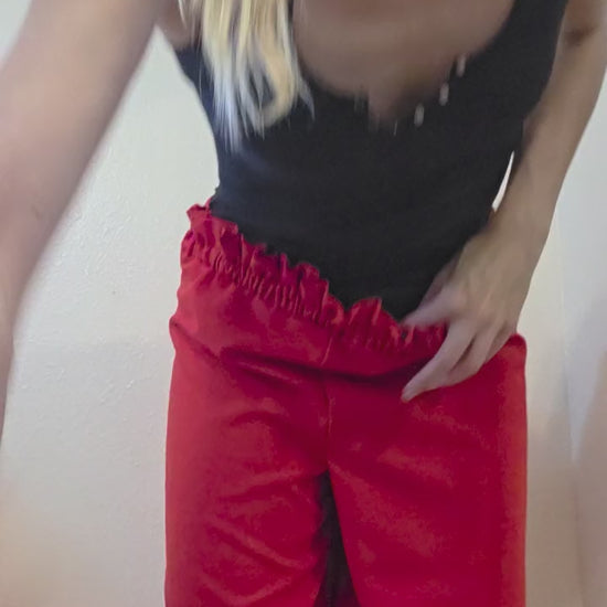 This photo shows a pair of red wide leg palazzo pants with a size- adjustable waistband. 